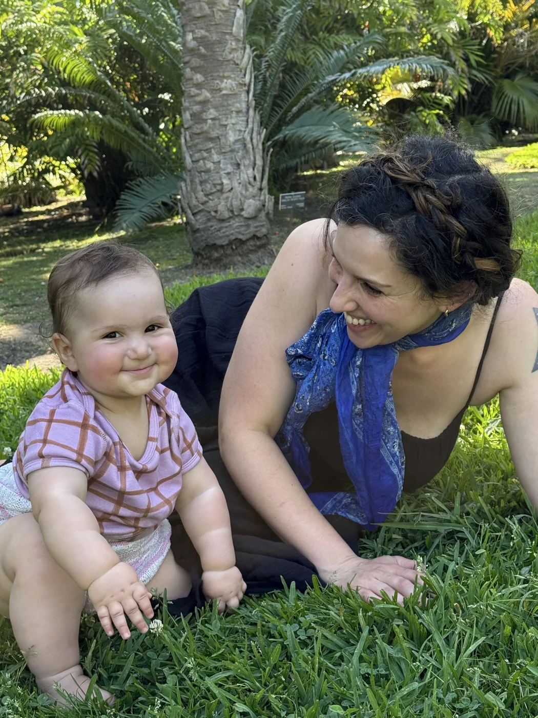 Jess smiling at Zosia as they sit together in the grass